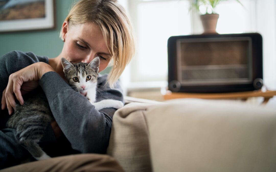 Owner cuddling her cat in her home